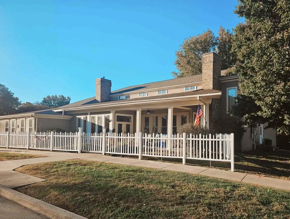 Century Assisted Living in Carbondale, IL — a residential house with a covered front porch and white picket fence