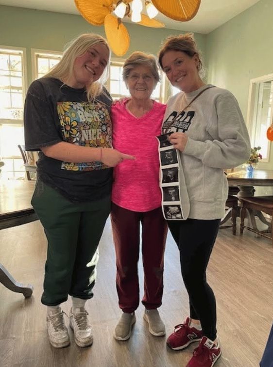 A resident with visiting family members sharing ultrasound photos of a new great-grandchild