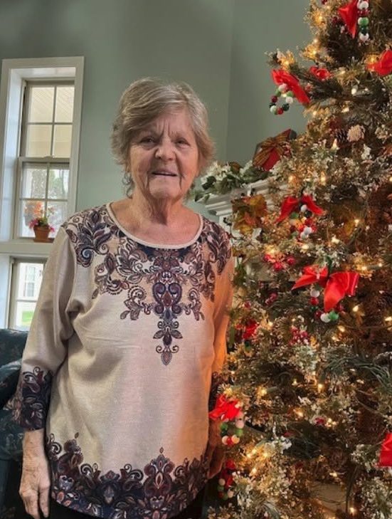A resident beside the Christmas tree at Century Assisted Living