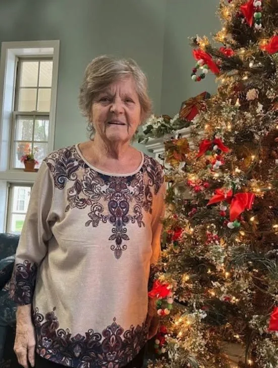 A resident beside the Christmas tree at Century Assisted Living